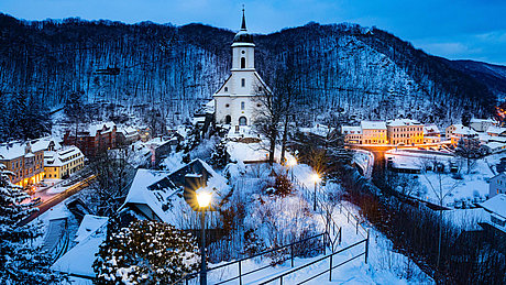 Blick auf ein beschneites Dorf mit Kirche.