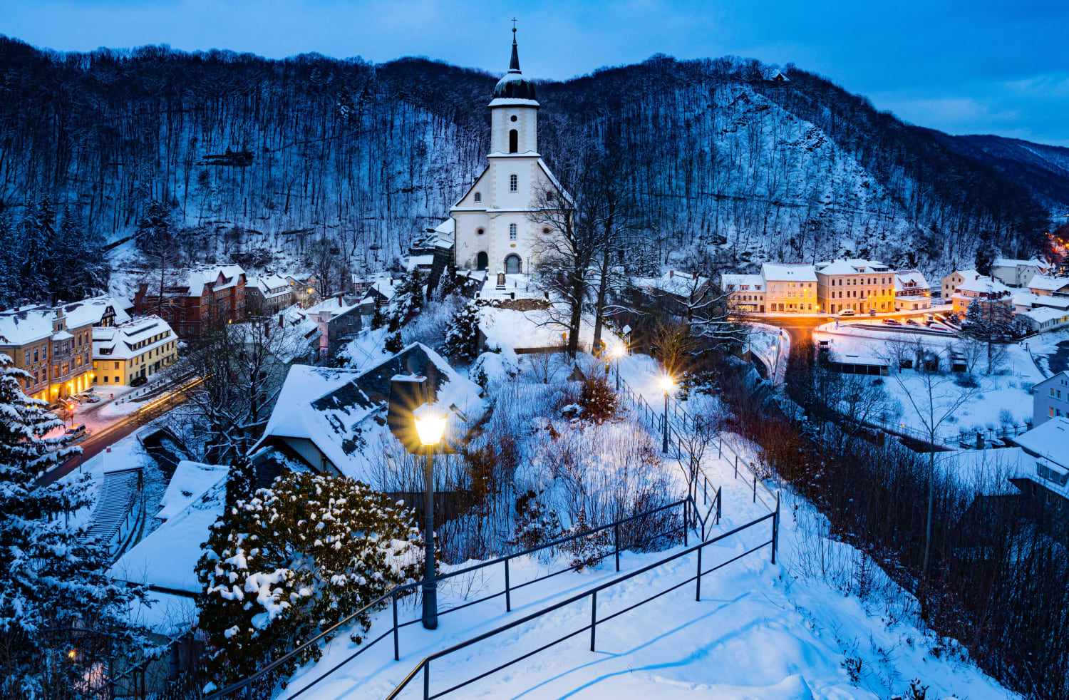 Blick auf ein beschneites Dorf mit Kirche. 