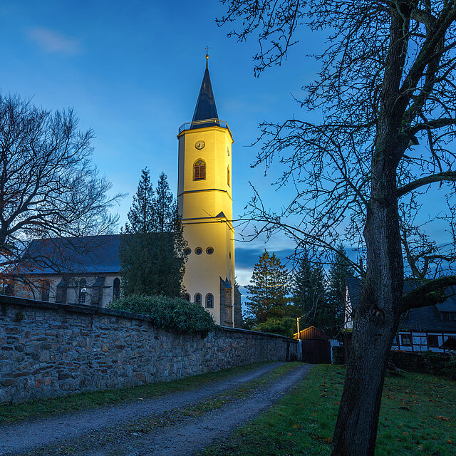 Eine Kirche mit angestrahltem Kirchturm.