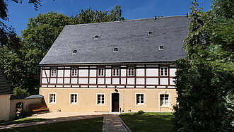 Vorderseite eines sanierten Pfarrhauses.