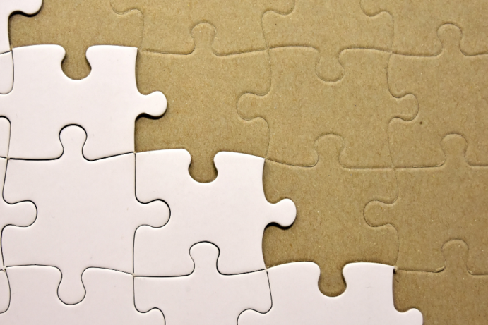 Bild, welches halbvoll mit weißen Puzzelsteinen belegt ist.