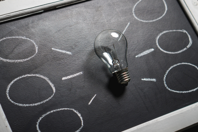 Tafel mit Glühbirne, welche zum Nachdenken anregen soll.